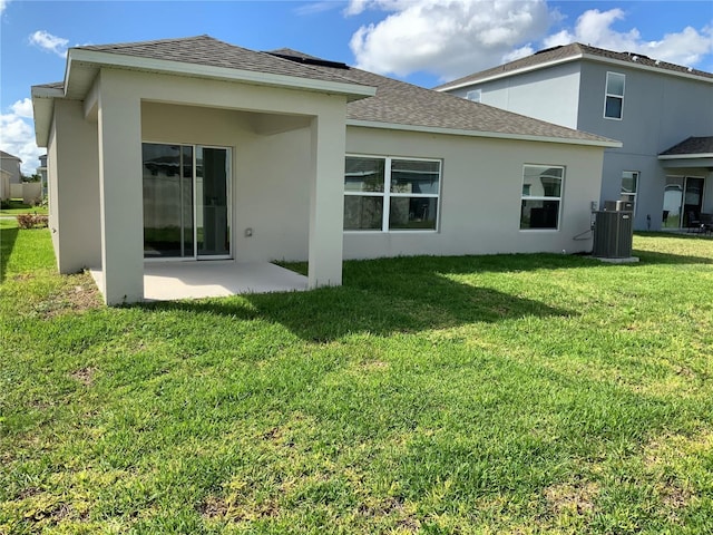 5639 Costa Blanca Way, Davenport, FL 33897 - rear view of property featuring central AC, a patio, stucco siding, a yard, and roof with shingles