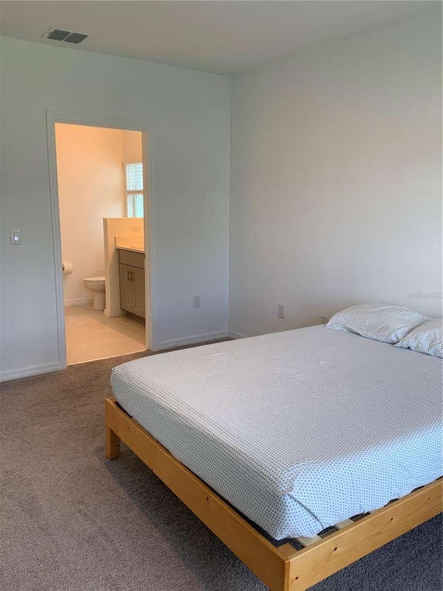 5639 Costa Blanca Way, Davenport, FL 33897 - bedroom featuring light carpet, ensuite bathroom, and baseboards