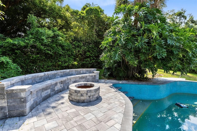 view of swimming pool with a patio and an outdoor fire pit