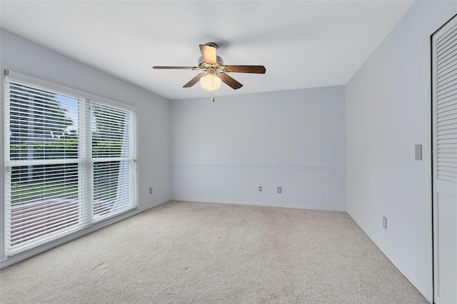 carpeted empty room featuring ceiling fan