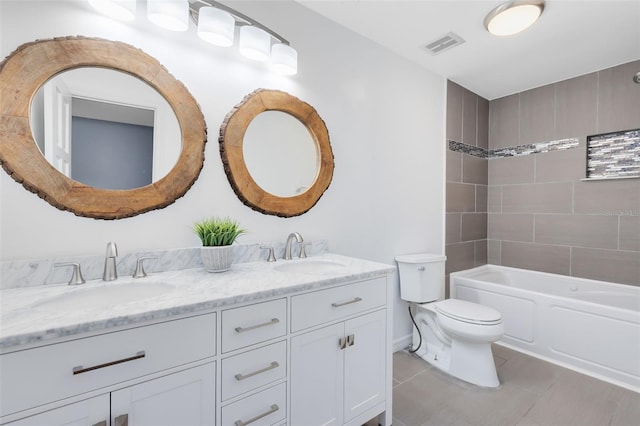 full bathroom with tile patterned flooring, toilet, tiled shower / bath, and vanity