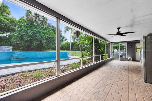 unfurnished sunroom with ceiling fan