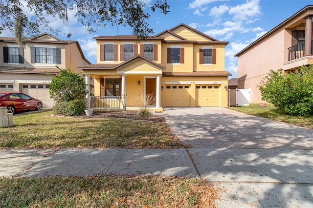 view of front of home featuring a porch, a garage, and a front lawn