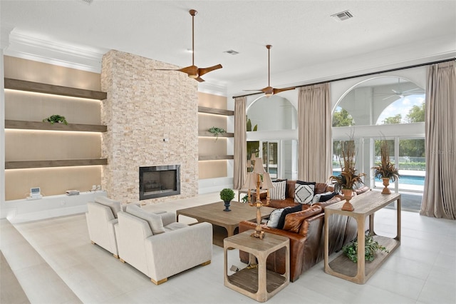 tiled living room with ceiling fan, a fireplace, a textured ceiling, and built in features