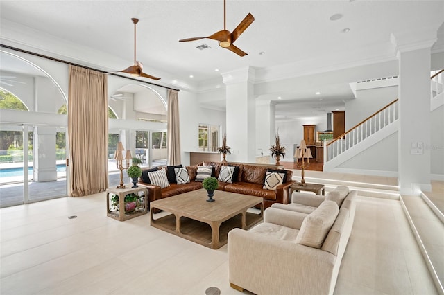 living room featuring ceiling fan, ornamental molding, and a towering ceiling