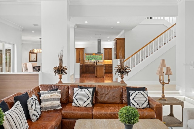 living room with hardwood / wood-style flooring, plenty of natural light, ornamental molding, and sink