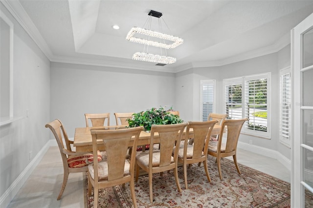 dining space with light tile patterned floors, crown molding, a tray ceiling, and a chandelier