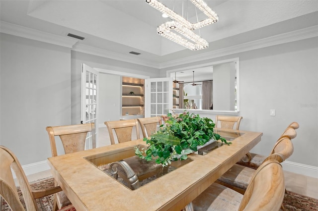 dining area with a chandelier, ornamental molding, french doors, tile patterned flooring, and a tray ceiling