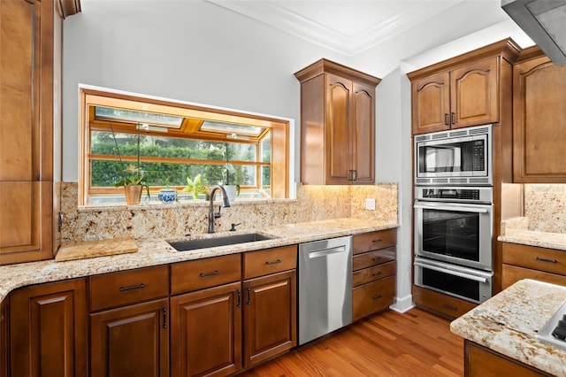 kitchen featuring sink, tasteful backsplash, appliances with stainless steel finishes, and wood-type flooring