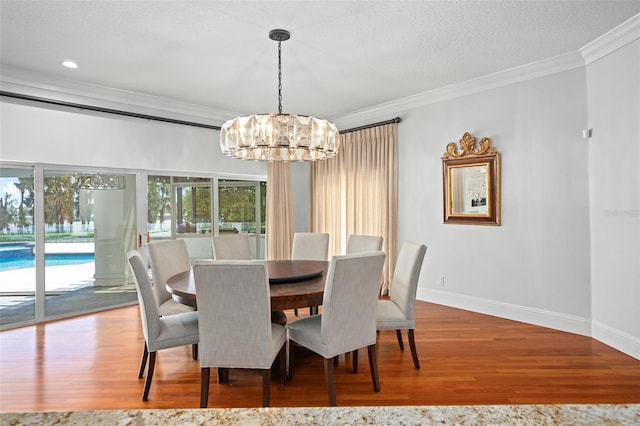 dining room with a textured ceiling, a notable chandelier, hardwood / wood-style floors, and ornamental molding