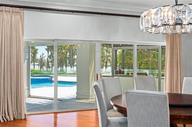 dining room featuring crown molding, hardwood / wood-style floors, and an inviting chandelier