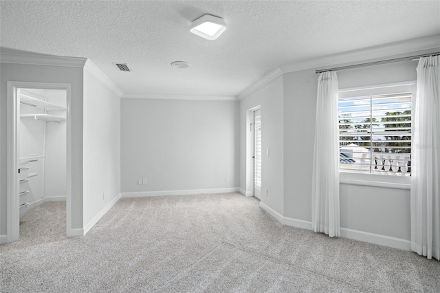 unfurnished bedroom featuring a spacious closet, crown molding, and light colored carpet