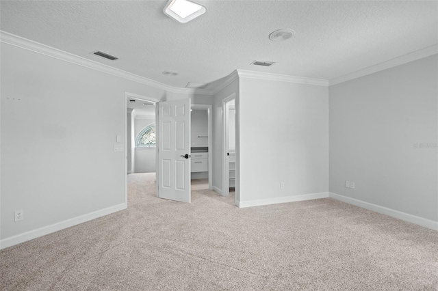 unfurnished bedroom featuring light colored carpet, a textured ceiling, and ornamental molding