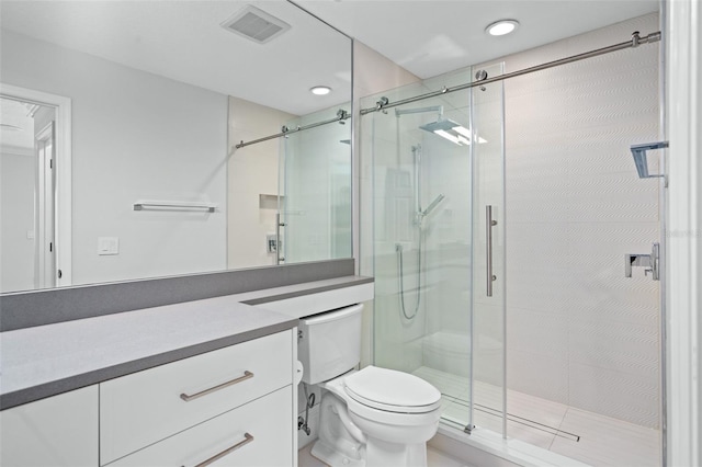 bathroom featuring a shower with door, toilet, and vanity