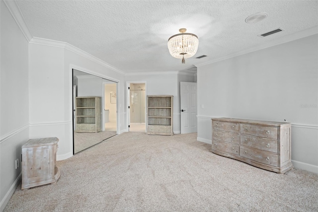 unfurnished bedroom with ornamental molding, a closet, a notable chandelier, a textured ceiling, and carpet floors