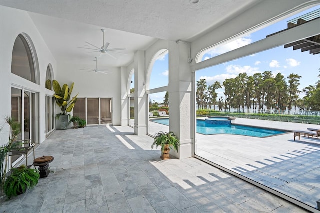 exterior space with ceiling fan, a patio area, and an in ground hot tub