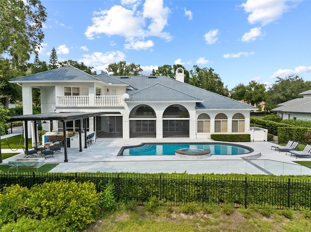 back of property featuring a balcony, a fenced in pool, and a patio area