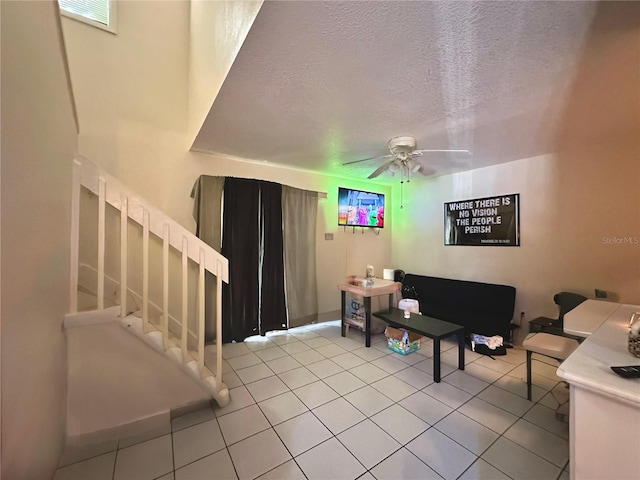 tiled living room with ceiling fan and a textured ceiling