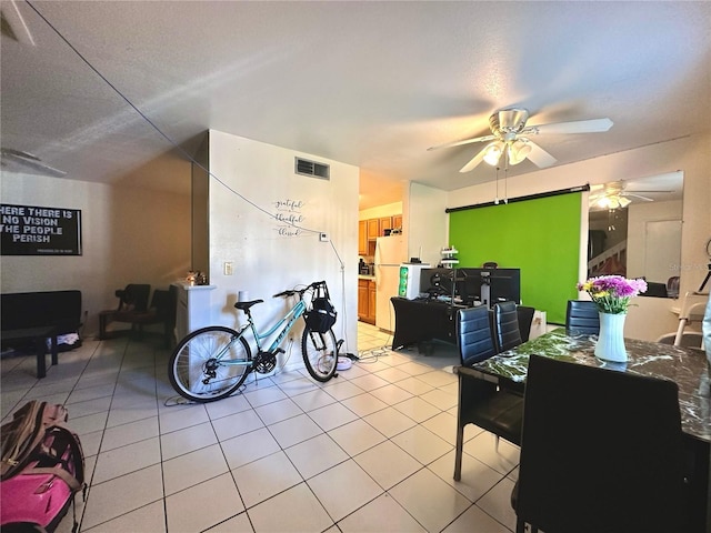 interior space featuring a textured ceiling, ceiling fan, and light tile patterned floors