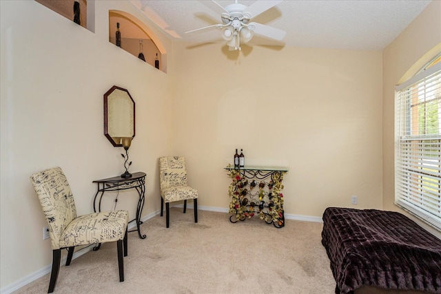 sitting room with ceiling fan, a textured ceiling, and carpet floors