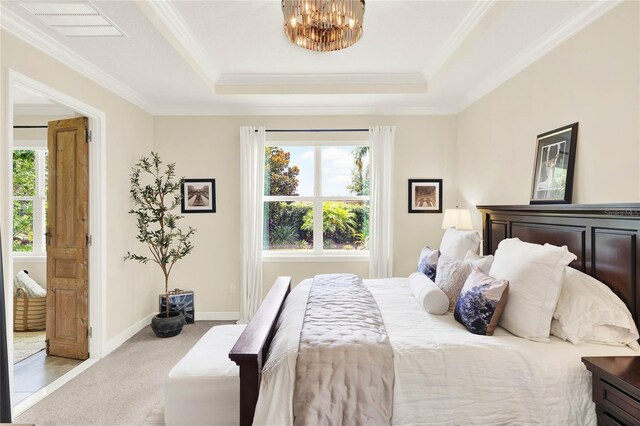 bedroom with a tray ceiling, light colored carpet, crown molding, and visible vents