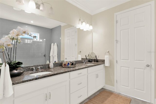 full bath featuring double vanity, ornamental molding, walk in shower, and a sink