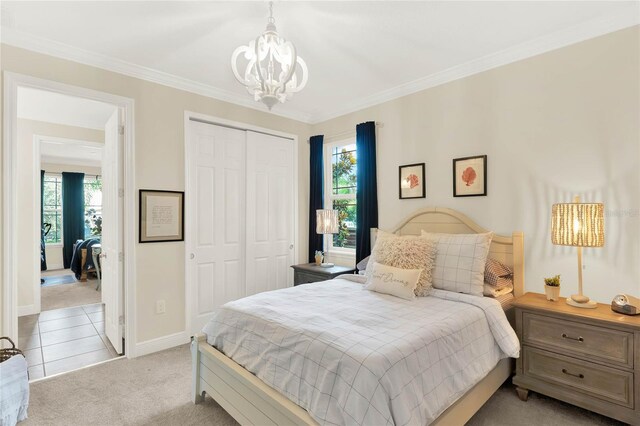 bedroom with light carpet, a notable chandelier, ornamental molding, and a closet