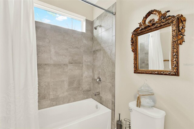 bathroom featuring toilet and shower / bathtub combination with curtain