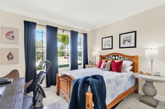 bedroom with light colored carpet and baseboards