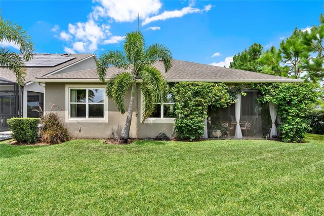 view of front facade featuring a shingled roof, a front lawn, and stucco siding