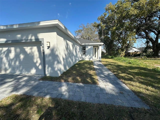 view of side of home with a garage and a yard