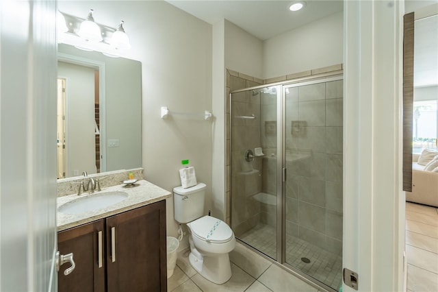 bathroom with a shower with door, toilet, tile patterned floors, and vanity