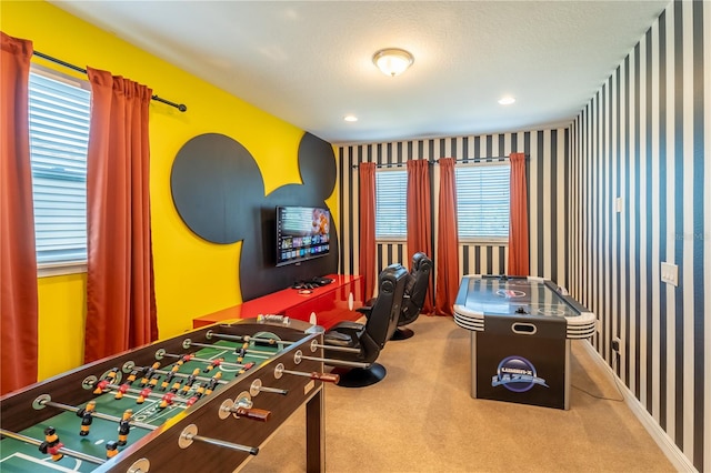 game room with a wealth of natural light, carpet, and a textured ceiling