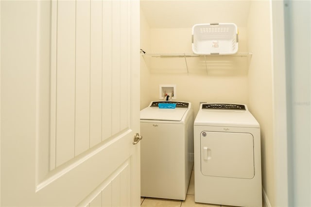 laundry room featuring light tile patterned flooring and separate washer and dryer