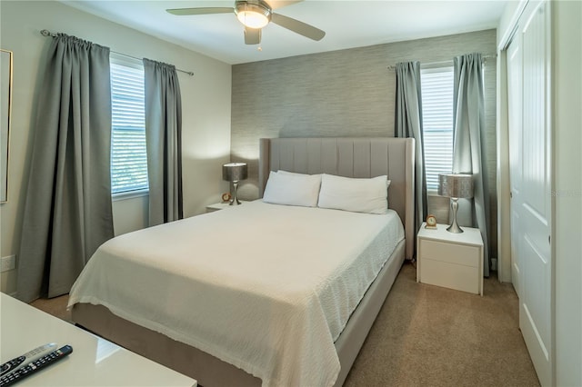 bedroom with ceiling fan and light colored carpet