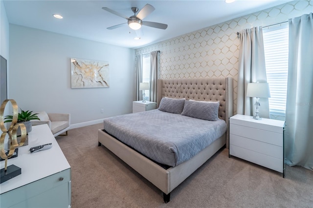 bedroom with ceiling fan, multiple windows, and light carpet