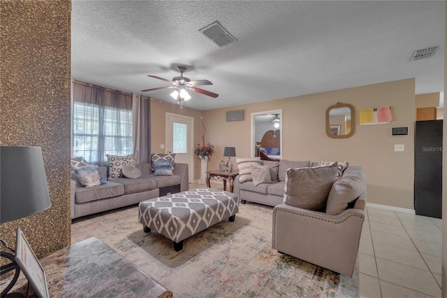 tiled living room with a textured ceiling and ceiling fan