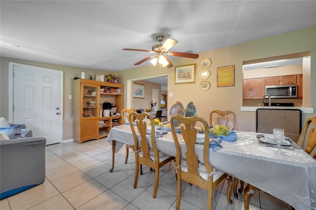 dining room with a textured ceiling, ceiling fan, and light tile patterned floors