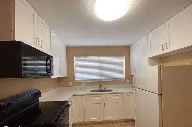 kitchen featuring white cabinetry, range, and white fridge