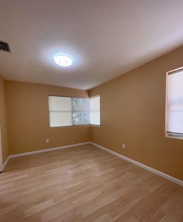 unfurnished room featuring light hardwood / wood-style floors and plenty of natural light