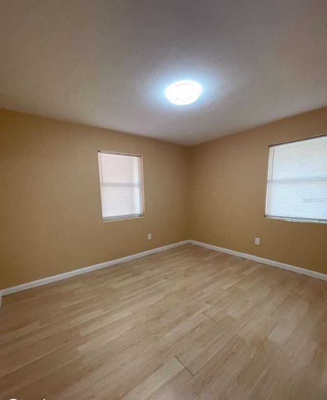 unfurnished room with light wood-type flooring