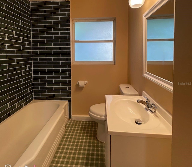 full bathroom featuring toilet, tiled shower / bath, vanity, and tile patterned floors