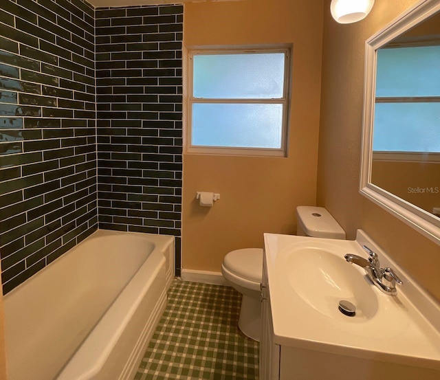 full bathroom with tile patterned flooring, toilet, tiled shower / bath combo, and vanity