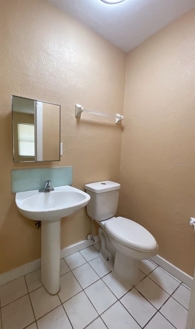 bathroom with toilet and tile patterned floors