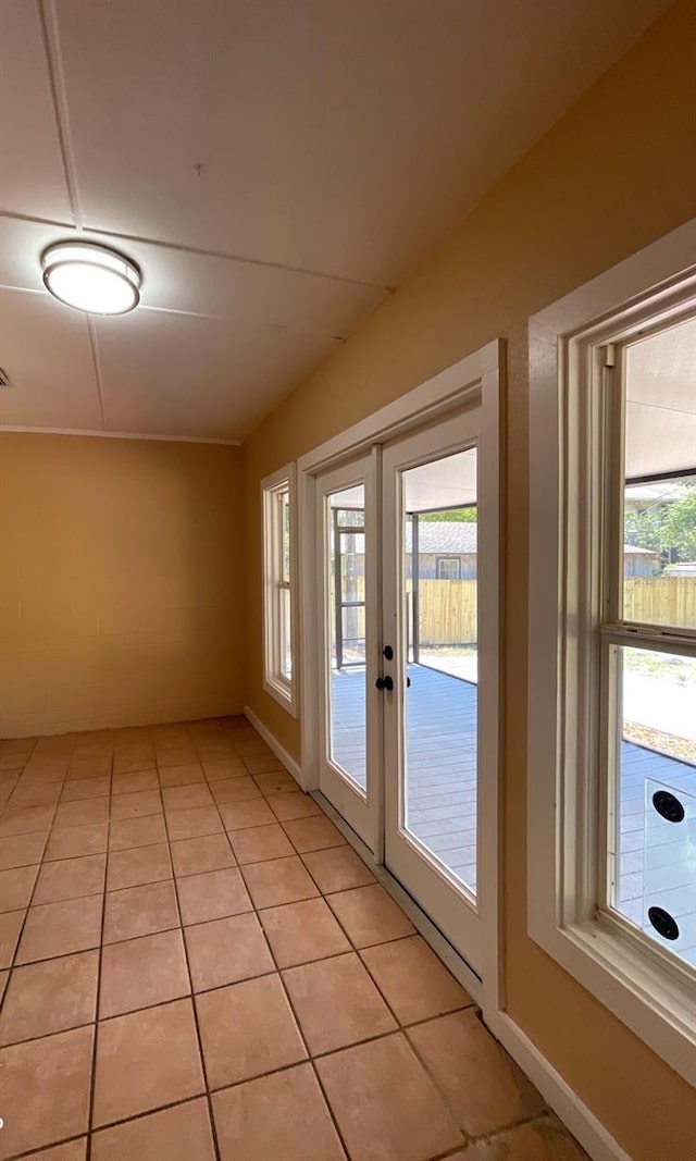 doorway with plenty of natural light, french doors, and light tile patterned floors