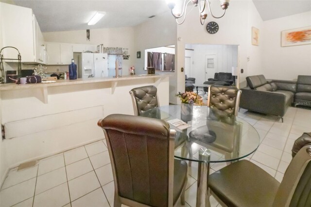 tiled dining space with a notable chandelier and vaulted ceiling