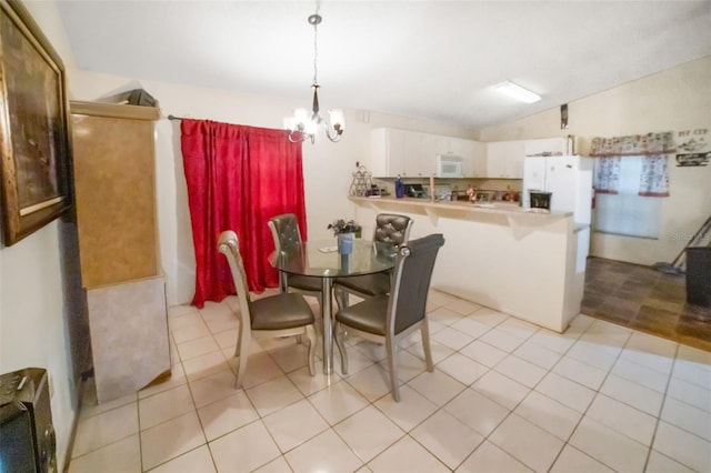 dining room featuring lofted ceiling, light tile patterned floors, and a notable chandelier