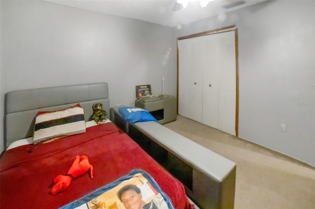 carpeted bedroom with ceiling fan and a closet