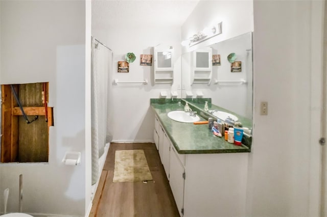 bathroom featuring curtained shower, hardwood / wood-style floors, and vanity