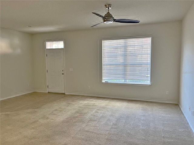 spare room with ceiling fan and light colored carpet